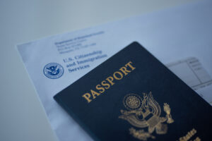 Letter from US Citizenship and Immigration Services covered Passport of United States of America on white surface.