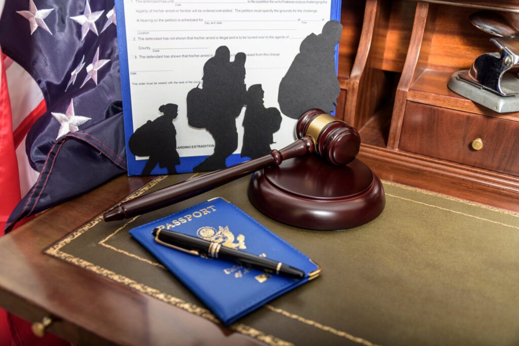 American flag next to a gavel, passport and Silhouette of immigrants on wooden table