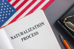 Notebook that says Naturalization Process next to an American Flag