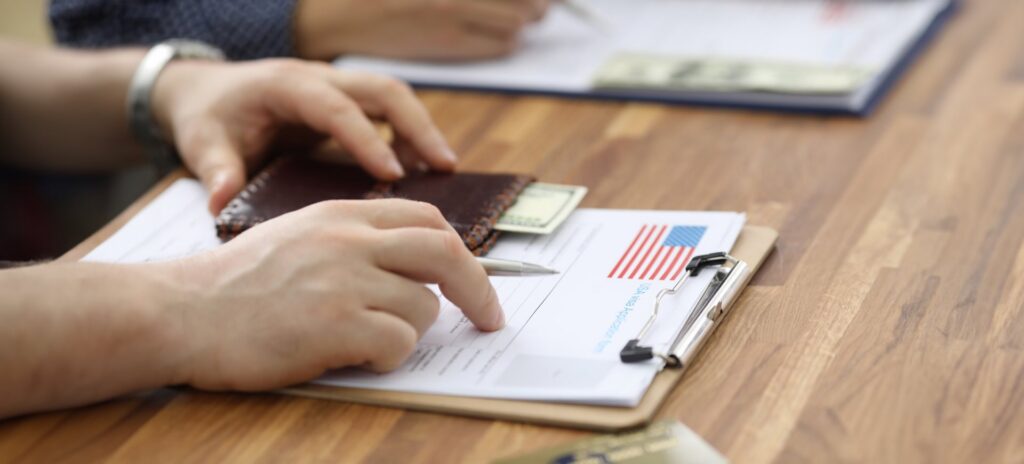 Male hands in suit lie on application for usa visa.