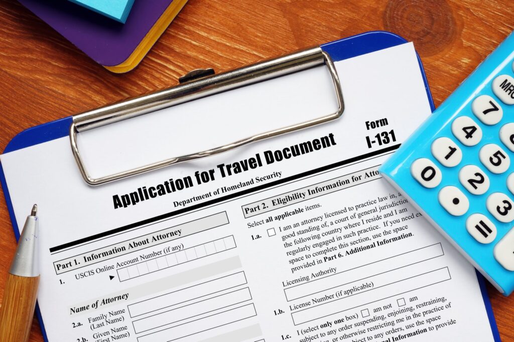 Form I-131 Application for Travel Document next to blue calculator on clipboard
