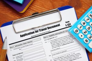 Form I-131 Application for Travel Document next to blue calculator on clipboard