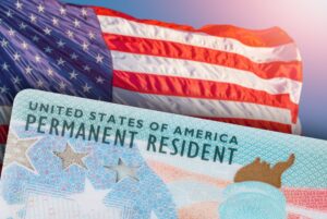 American flag and green card with a sky background