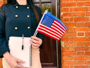 Woman in a blue shirt and white skirt holding an American flag