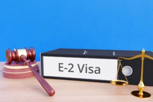 E-2 Visa on folder with gavel and justice of scales