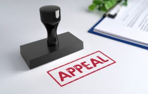 Black stamp and red stamp that says appeal next to a clipboard