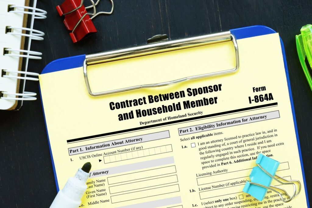 Clipboard with Form I-864A on it