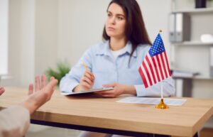 Two people sitting at a desk with an American Flag on it