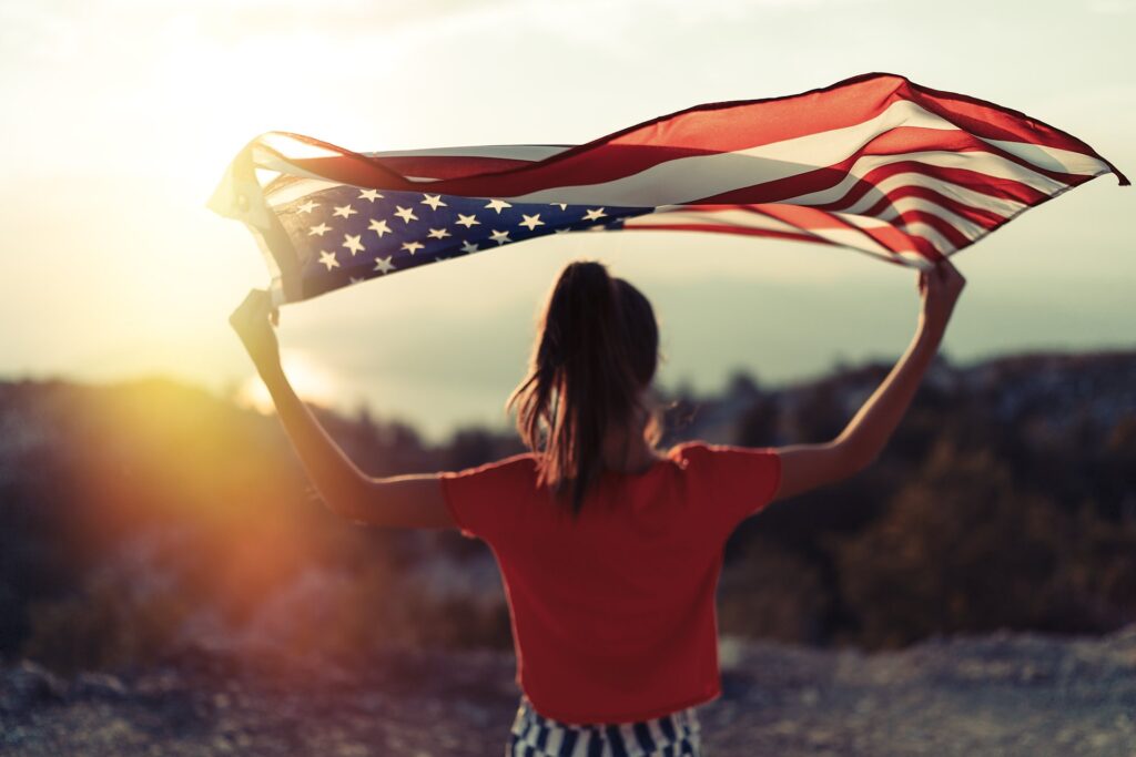 Woman holding american flag with a desert as the background