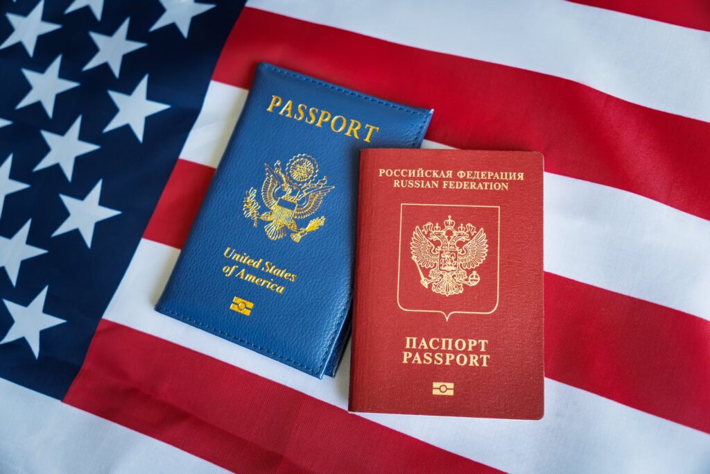 Two passports from different states laying on the American flag