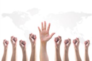 9 hands in the air 8 of them have fists closed and one hand is open with a white background