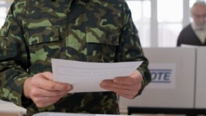 Person in military uniform holding a piece of paper