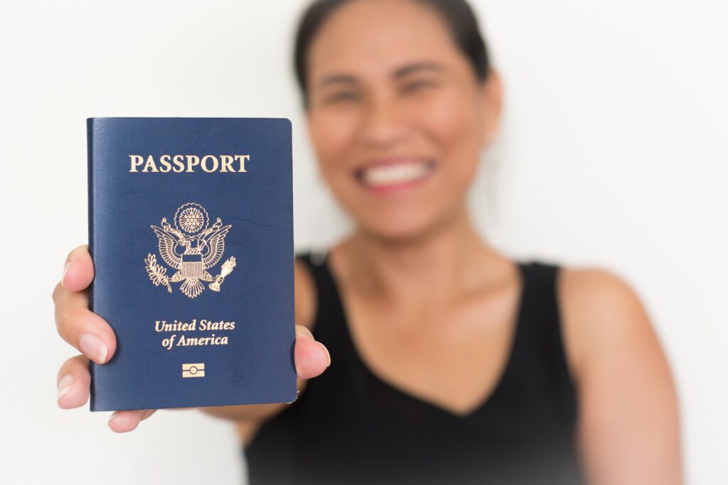 Proud New American Citizen Holding a US passport | Citizenship Lawyer | U.S. Immigration Law Counsel