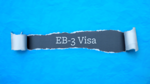 Blue Piece of paper ripped with the words EB-3 Visa in the center