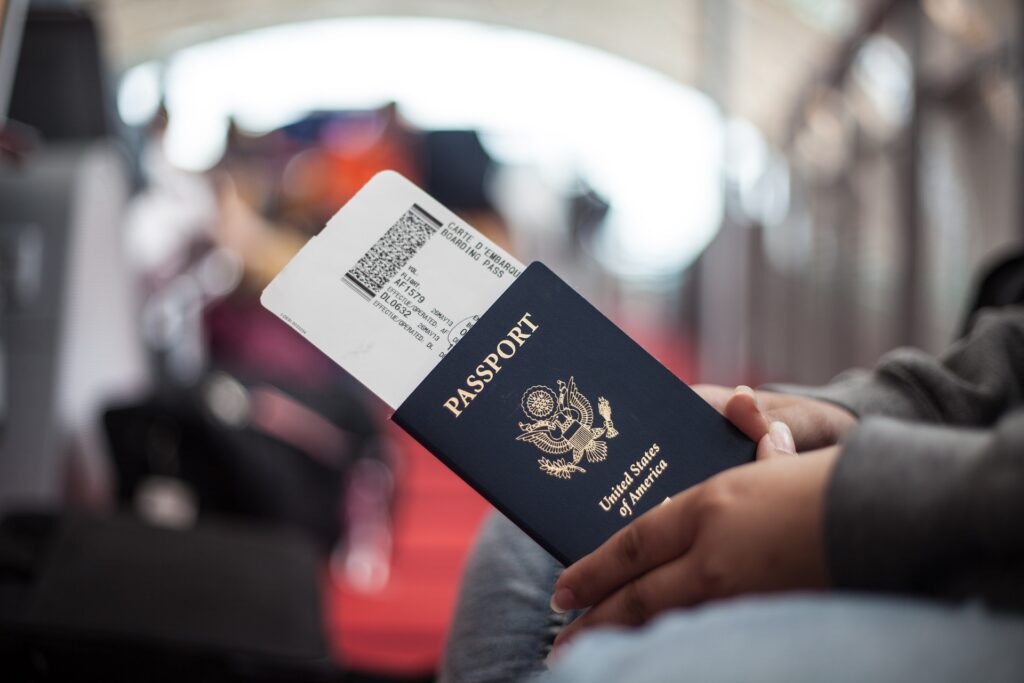 Woman Holding American Passport in Airport | H1B Visa Attorneys | U.S. Immigration Law Counsel