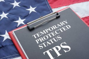 American flag with a clipboard ontop that says Temporary Protected Status TPS